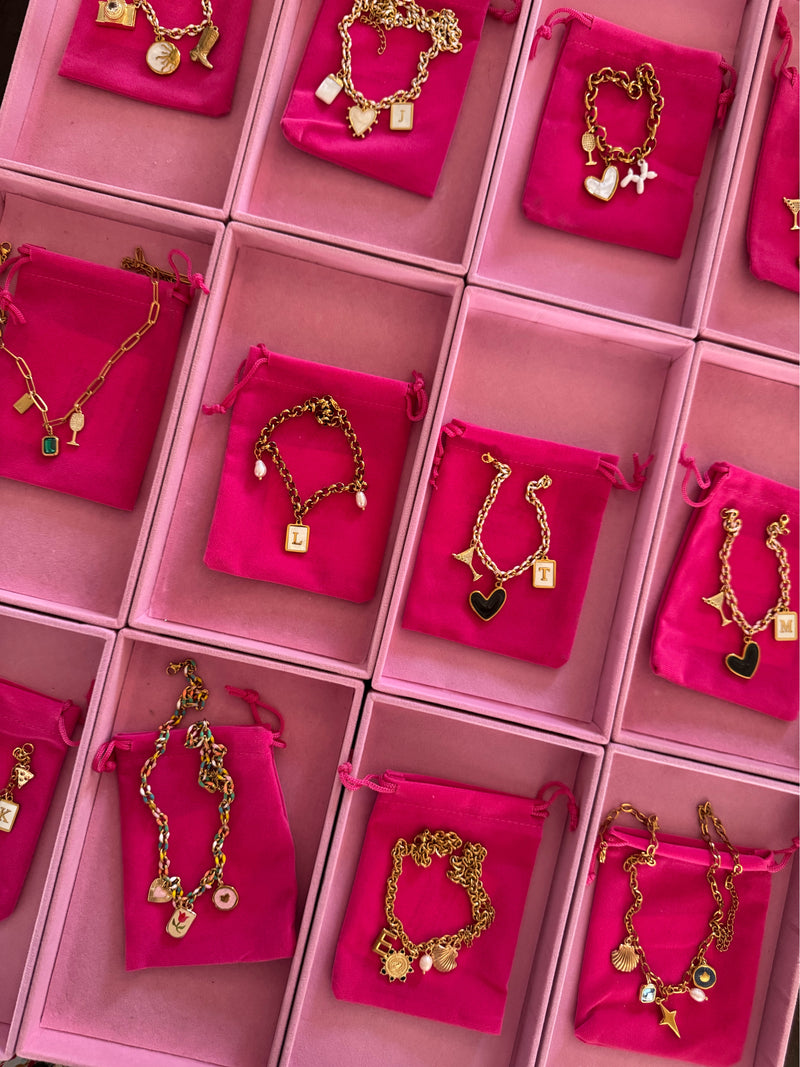 Charm bar trays of gold charms and bracelets at a Club Sweat event with Get Charmed Co.