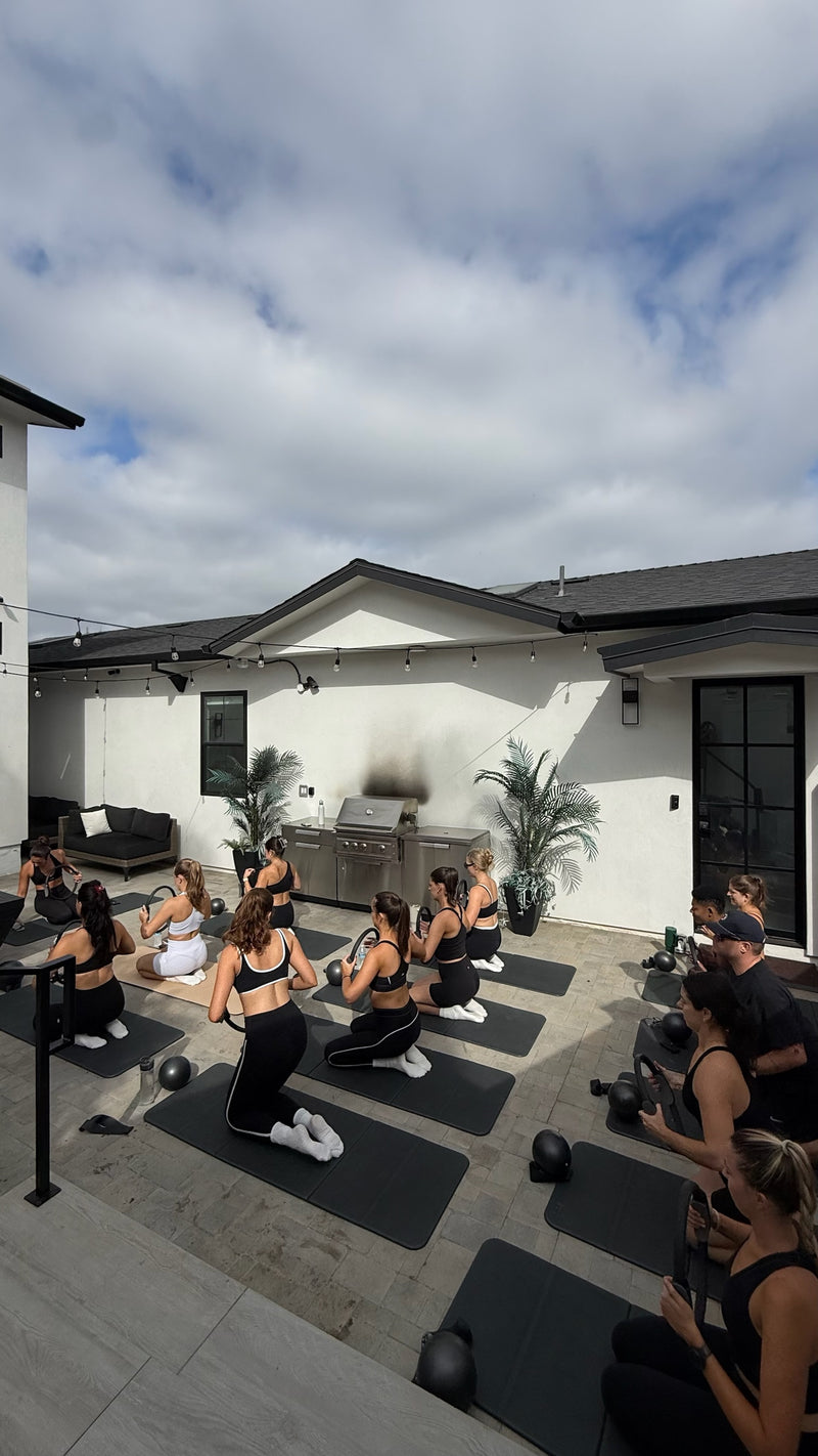 Private group Pilates class on mats in a San Diego backyard with Club Sweat