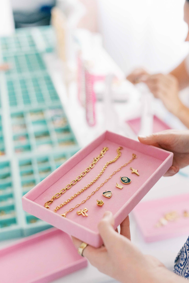 Charm bar tray of gold charms and bracelets at Get Charmed Co. in Tampa, a Club Sweat partner
