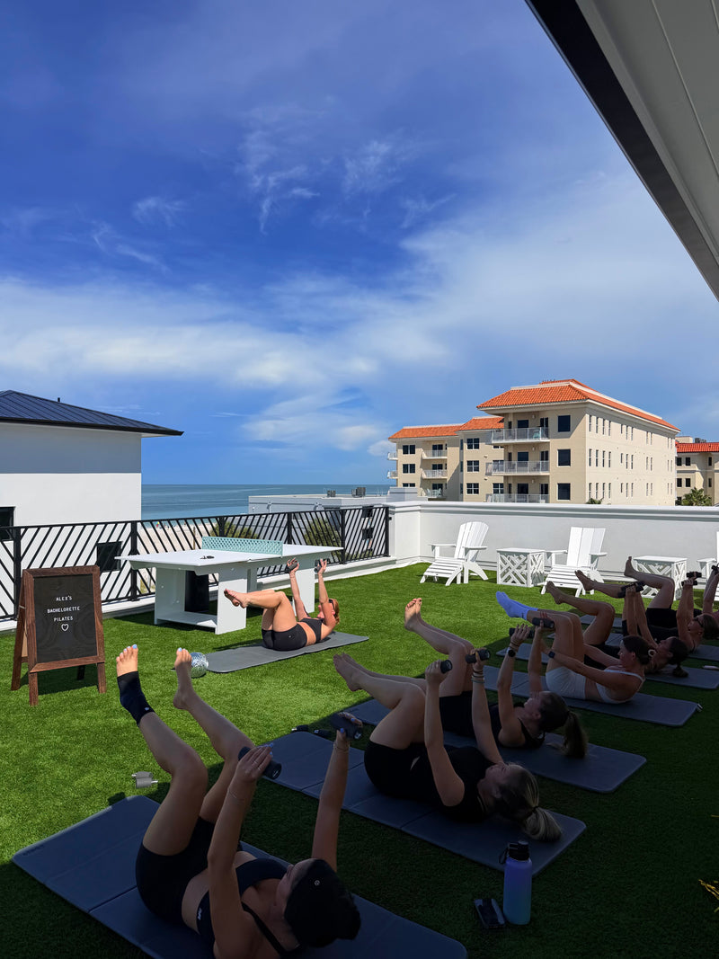 Rooftop Pilates class on mats overlooking the water at a Tampa bachelorette workout with Club Sweat